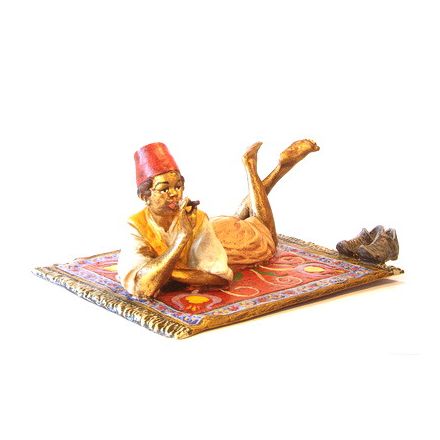 Orient. Bub mit Zigarre auf Teppich/Schuhe